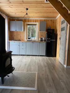 a kitchen with white cabinets and a black refrigerator at Dolina Jelenia in Gorczyca +32 photos