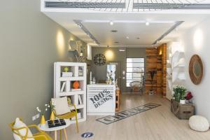 a living room with a table and chairs and a clock at Copacabana Hotel Design in Margherita di Savoia
