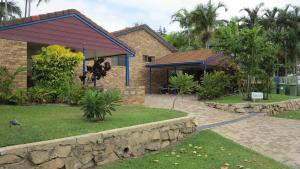 a house with a stone wall in front of a yard at Magnetic Shores Unit 2 in Arcadia