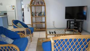 a living room with blue chairs and a flat screen tv at Magnetic Shores Unit 2 in Arcadia