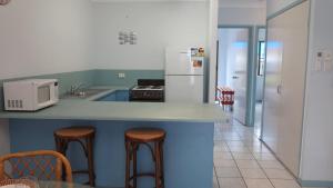 a kitchen with a counter with stools and a refrigerator at Magnetic Shores Unit 2 in Arcadia