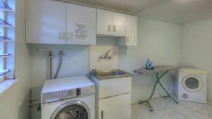 una pequeña cocina con lavadora y fregadero en Loyang Apartment 2 en Arcadia