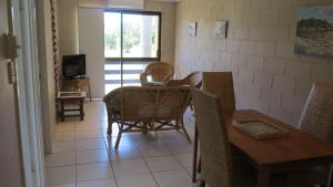 uma sala de jantar com uma mesa e cadeiras e uma televisão em Casual Lodge Unit 4 em Nelly Bay