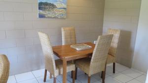 uma sala de jantar com uma mesa de madeira e cadeiras em Casual Lodge Unit 4 em Nelly Bay