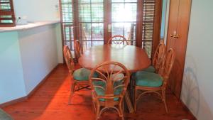 Una mesa de comedor con sillas y una mesa de madera. en Kameruka, en Arcadia 8 fotos más