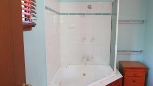Un baño blanco con bañera y lavabo. en Kameruka, en Arcadia