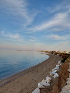 a beach with a row of rocks on the shore at Luxury 3BR Sunrise Villa , Seaside Gyrismata in Skiros