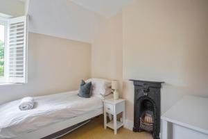 een slaapkamer met een bed en een open haard bij Clover Cottage in Wyck Rissington