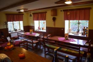 a dining room with tables and chairs and windows at Ubytování - U nás doma in Orličky