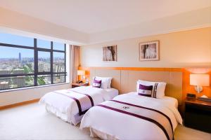 Postel nebo postele na pokoji v ubytování Kunshan Yu Yuan Garden Hotel