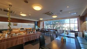 un restaurant avec des tables, des chaises et un comptoir dans l'établissement Nobeoka Urban Hotel, à Nobeoka