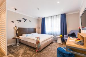 een hotelkamer met een bed, een bureau en een bank bij Romantik Hotel Reichshof in Norden