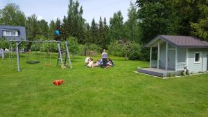 a group of people in a yard with a playground at Vanasauna Guesthouse in Valma