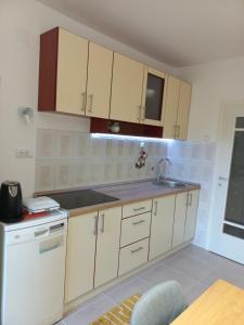 a kitchen with white cabinets and a sink at Corso Residence in Bajina Bašta