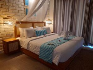 a bedroom with a large bed with two lights on it at Oruwa Boutique Villas in Arugam Bay