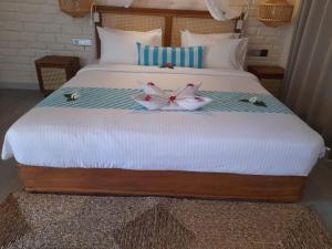 a bed with two flowers on top of it at Oruwa Boutique Villas in Arugam Bay