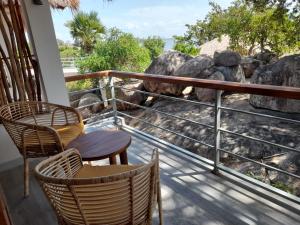 a balcony with chairs and a view of rocks at Oruwa Boutique Villas in Arugam Bay