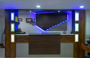 a lobby with a staircase with purple lighting at Indraprastham Tourist Home in Kottayam