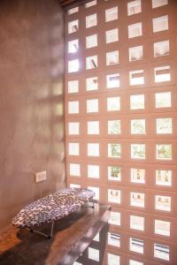 a bench in front of a wall with a window at Ngam Hidden Cabin Room in Thongsala