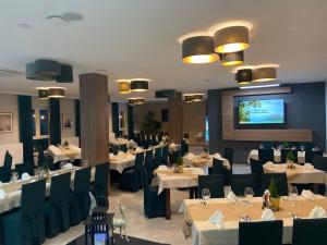 a restaurant with tables and chairs and a flat screen tv at Szelesiówka & SPA in Chodzież