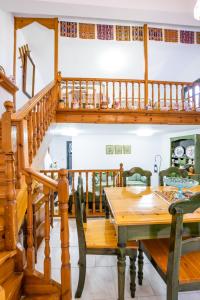 a dining room with a wooden table and a staircase at Mertonas Villa in Karpathos