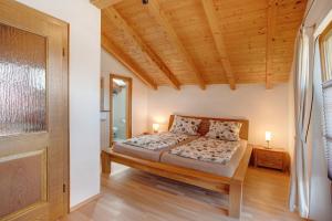 ein Schlafzimmer mit einem Bett und einer Holzdecke in der Unterkunft Josys Ferienwohnung in Gstadt am Chiemsee