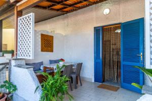 a patio with a blue door and a table and chairs at Perla marina in Grosseto