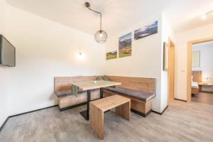 a dining room with a table and benches at Bliem, Apartment in Finkenberg