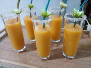 a group of glasses of orange juice on a table at Oruwa Boutique Villas in Arugam Bay
