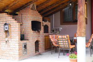 an outdoor brick oven with chairs and a table at Casa Darius in Novaci-Străini