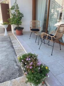 a patio with two chairs and flowers and a table at La casa di Colino e Annina in Monopoli