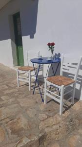 a blue table with two chairs and a table with a vase on it at BAROS VIEW in Apérathos