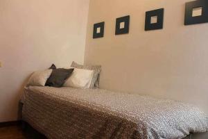 1 dormitorio con 1 cama con 4 cuadros en la pared en Amplio y luminoso apartamento en Villaviciosa en Villaviciosa