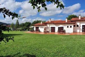 a white house with a large green yard at Apartamento familiar cercano a playa de Rodiles 3 in Villaviciosa