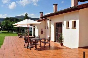 a patio with a table and chairs and an umbrella at Apartamento familiar cercano a playa de Rodiles. 6 in Villaviciosa