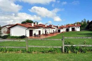 a row of houses in a field behind a fence at Apartamento familiar cercano a playa de Rodiles. 6 in Villaviciosa +12 photos