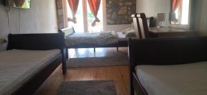 a room with two beds and a table and a window at Djevojački Most in Kolašin