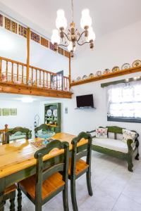 jadalnia ze stołem, krzesłami i kanapą w obiekcie Mertonas Villa w mieście Karpatos