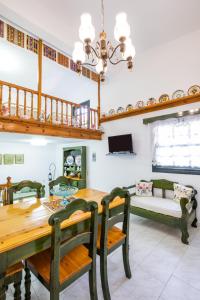 a dining room with a table and chairs and a couch at Mertonas Villa in Karpathos