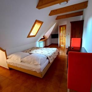 um quarto com uma cama e uma cadeira vermelha em Kazkowa Koliba em Zakopane