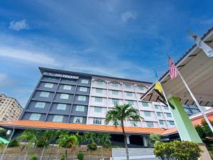 a hotel with an american flag in front of it at Raia Inn Penang in Bayan Lepas