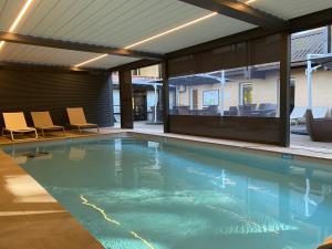 アンネヴィルにあるEnzo Hôtels Diane - Logis Amnévilleの建物の中に椅子が置かれた大きなプール