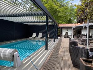 een buitenzwembad met een pergola en een zonneterras bij Enzo Hôtels Diane - Logis Amnéville in Amnéville