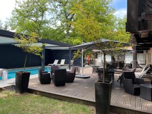 - une terrasse avec des chaises et un parasol à côté de la piscine dans l'établissement Enzo Hôtels Diane - Logis Amnéville, à Amnéville