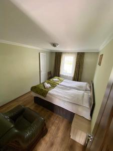 a bedroom with a large bed and a couch at Nino's Guest House in Stepantsminda
