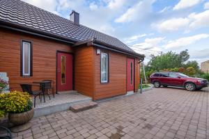 uma pequena casa com um carro estacionado ao lado em LIUX apartamentai em Kaunas