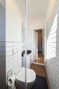 baño blanco con aseo y pasillo en Green Leaf Apartment en Zagreb