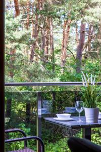 - une table avec un verre de vin sur le balcon dans l'établissement Lagūna - Šventoji, à Šventoji