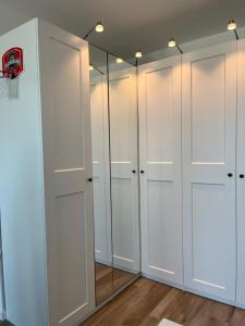 a dressing room with white closets and a mirror at Sweet Home in Milano smart district in Milan