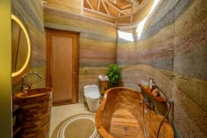 Ulaman Eco Luxury Resort في تابانان: حمام مع حوض خشبي ومرحاض